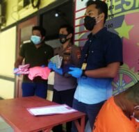 Pelaku sedang jongkok dan menunduk di samping petugas. (Foto : Polresta Samarinda)