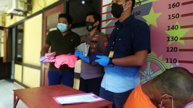 Pelaku sedang jongkok dan menunduk di samping petugas. (Foto : Polresta Samarinda)