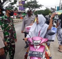 Berita Kaltim Terkini - Petugas gabungan menegur Ema-ema yang tidak memakai masker ketika mengendarai motor