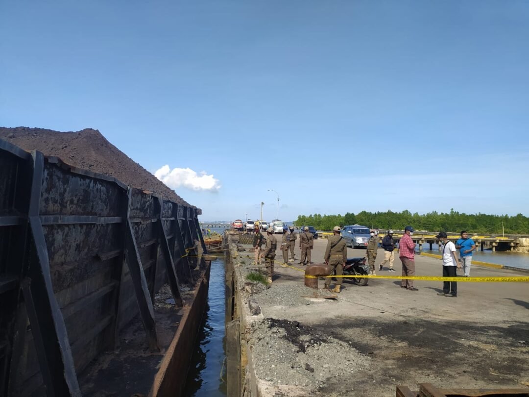 Proses pemasangan garis polisi di area loading batubara di Pelabuhan Buluminung.