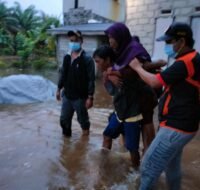 Salah satu warga korban terdampak banjir diselamatkan oleh personel BPBD yang dibantu warga. (Ist)