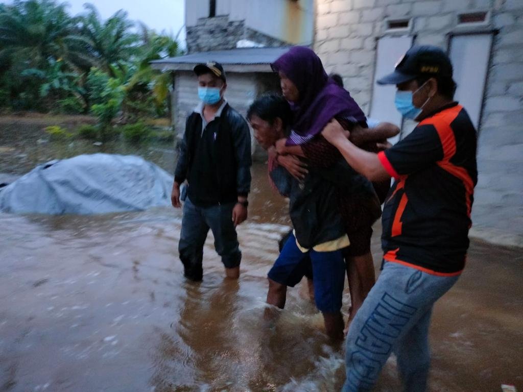 Salah satu warga korban terdampak banjir diselamatkan oleh personel BPBD yang dibantu warga. (Ist)